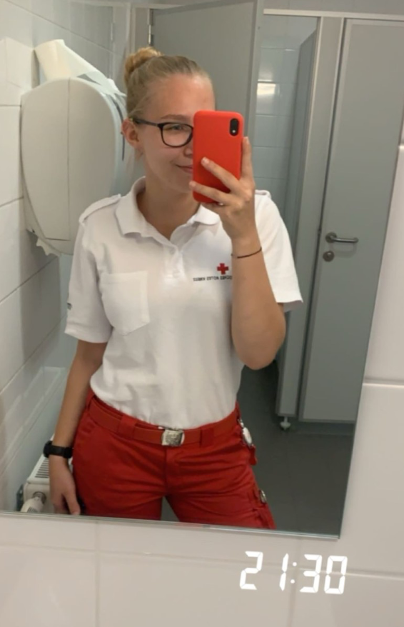 Blonde Frau im Rettungsdienst-Outfit im Rettungswagen